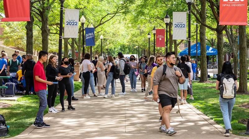 A busy campus sidewalk filled with students